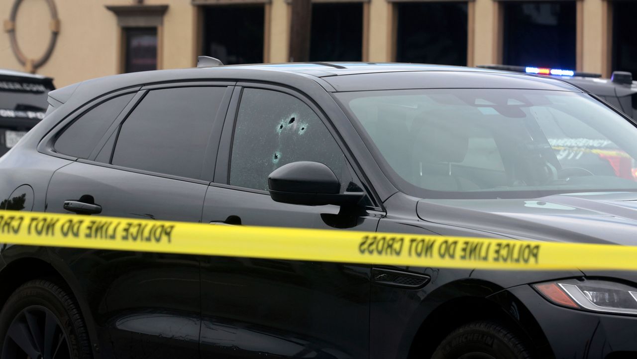 Investigators examine the scene where authorities say a Texas deputy constable was fatally shot at a Houston intersection while driving to work on Tuesday, Sept. 3, 2024. (AP Photo/Lekan Oyekanmi)