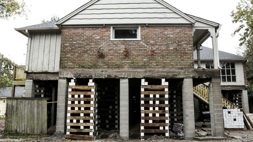 In this Wednesday, Dec. 6, 2017 photo, a home in the Meyerland neighborhood of Houston is in the process of being raised by Arkitekture Development. More than 1,600 Houston residents whose properties flooded during and after Hurricane Harvey may need to elevate their homes if they wants to continue living there. (Elizabeth Conley/Houston Chronicle via AP)