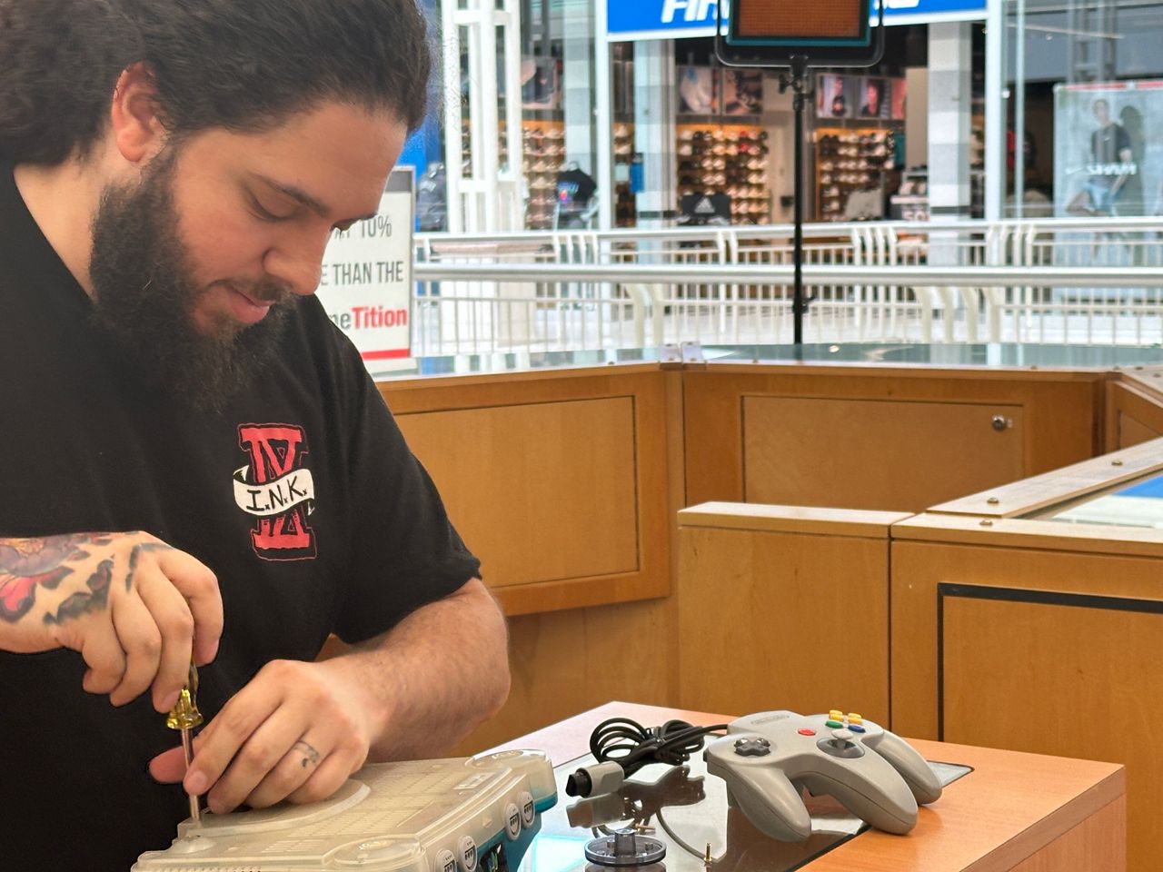 Ozzy Perez, a manager at Hudson's Video Games at Seminole Towne Center, works to repair a Nintendo 64 console. (Spectrum News/Destiny Wiggins)