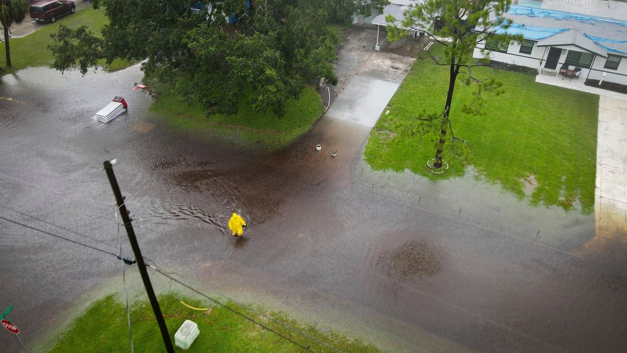 A pedestrian wades across a flooded street as a result of then-Tropical Storm Debby in the Shore Acres area of St. Petersburg, Fla., on Sunday, Aug. 4, 2024. (Max Chesnes/Tampa Bay Times via AP)