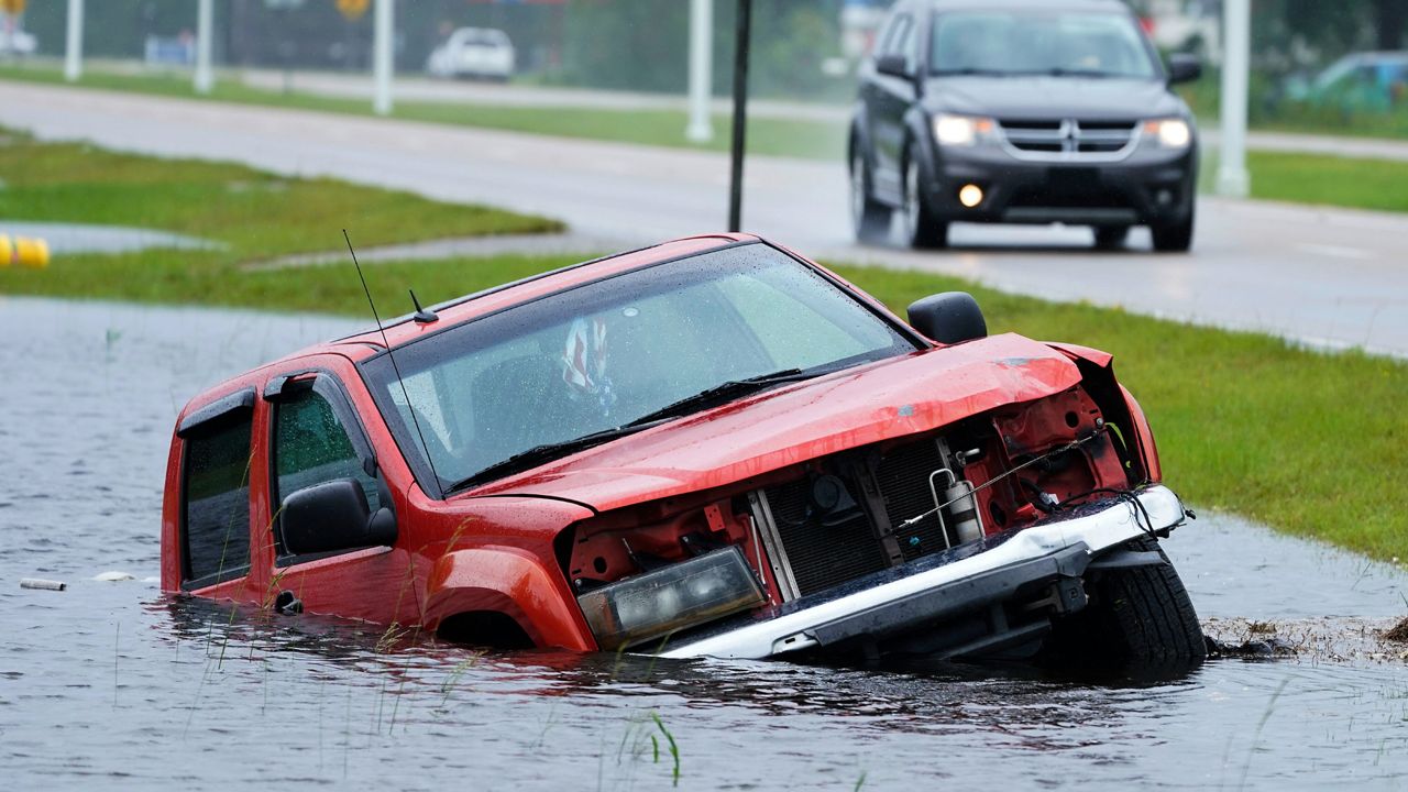 A pickup is abandoned and partially submerged on the side of a highway in Bay Saint Louis, Miss. (AP/Steve Helber)