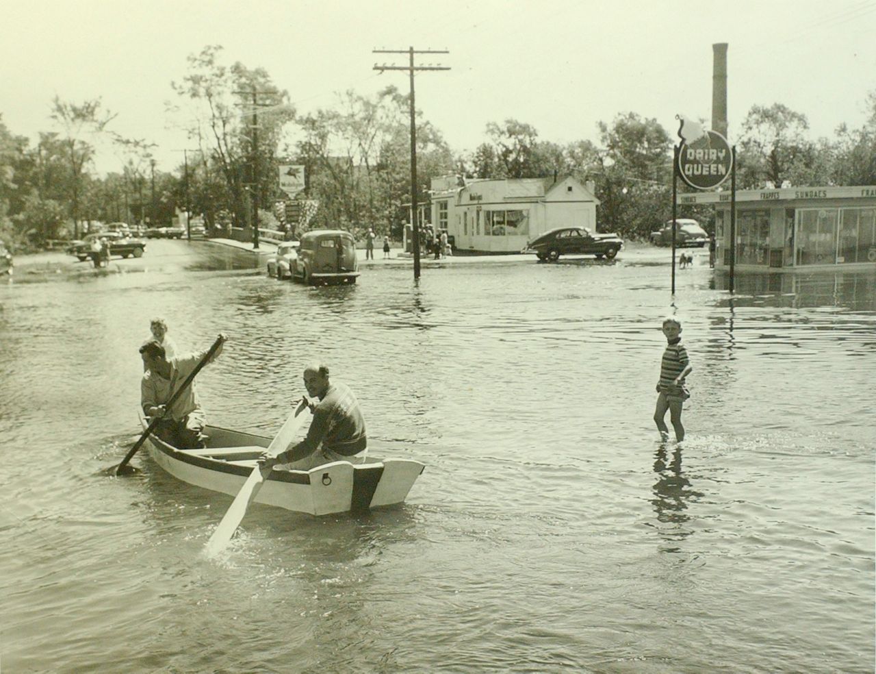 In this Sept. 1954 photo, two men row a dory along Union Avenue in Framingham, Mass., after the overflow of the Sudbury River as a result of Hurricane Edna. (AP Photo/Boston Public Library)