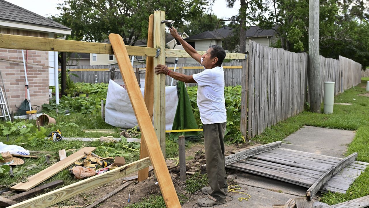 Adrian Hernandez repairs his fence after it was destroyed by Hurricane Beryl in Houston, Wednesday, July 10, 2024. (AP Photo/Maria Lysaker)