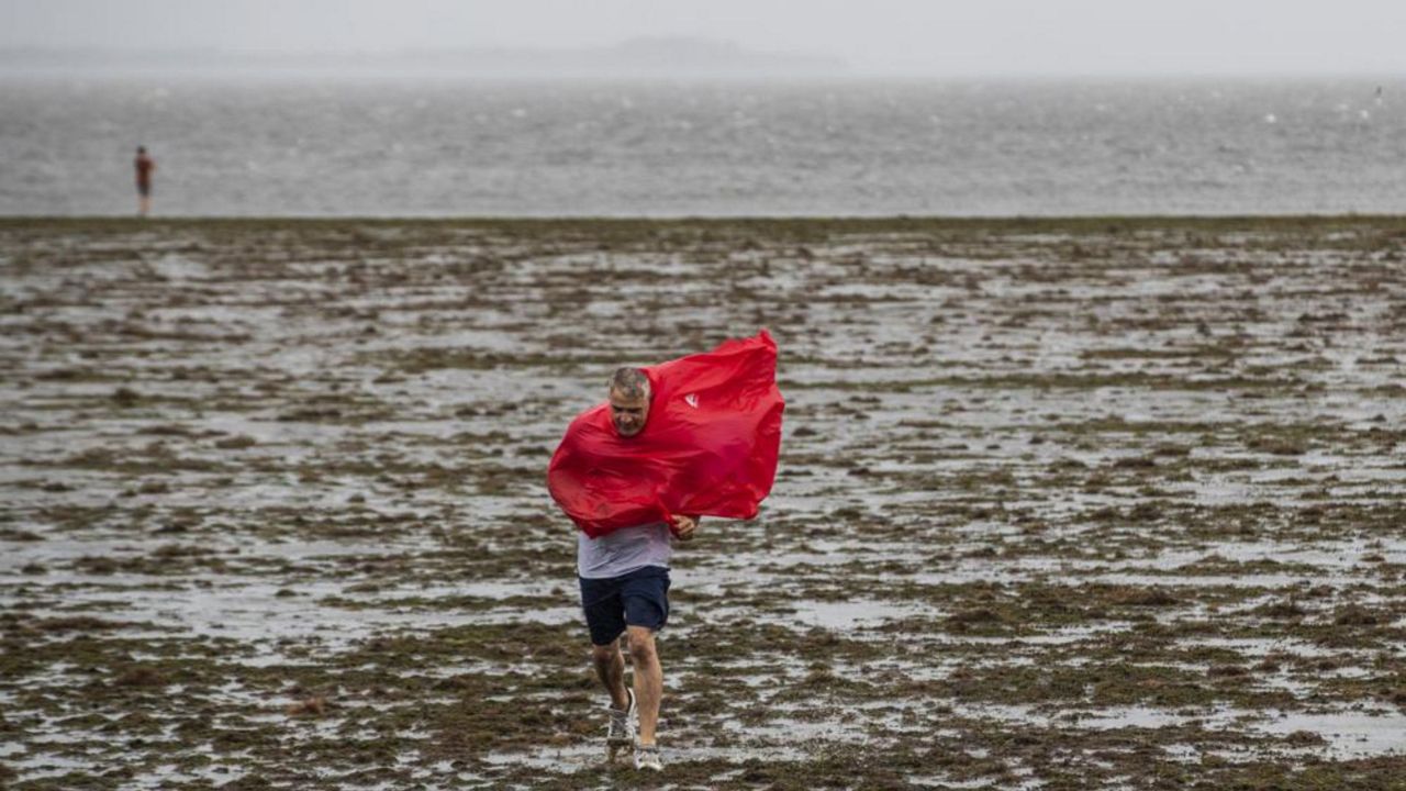 Curious sightseers walk in the receding waters of Tampa Bay due to the low tide and tremendous winds from Hurricane Ian in Tampa, Fla., Wednesday, Sept. 28, 2022. (Willie J. Allen Jr./Orlando Sentinel via AP)