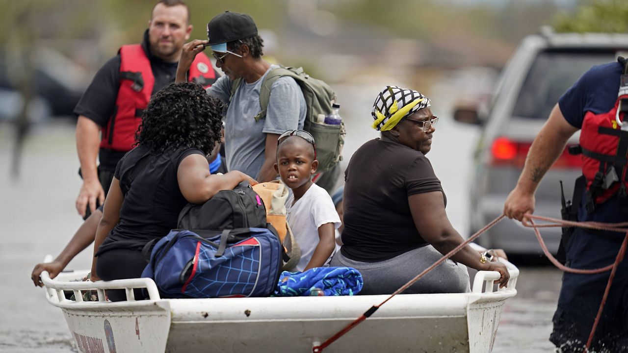 Members of the Louisiana State Fire Marshal's office rescue people from floodwaters in the aftermath of Hurricane Ida in New Orleans on Monday. (AP Photo/Gerald Herbert)
