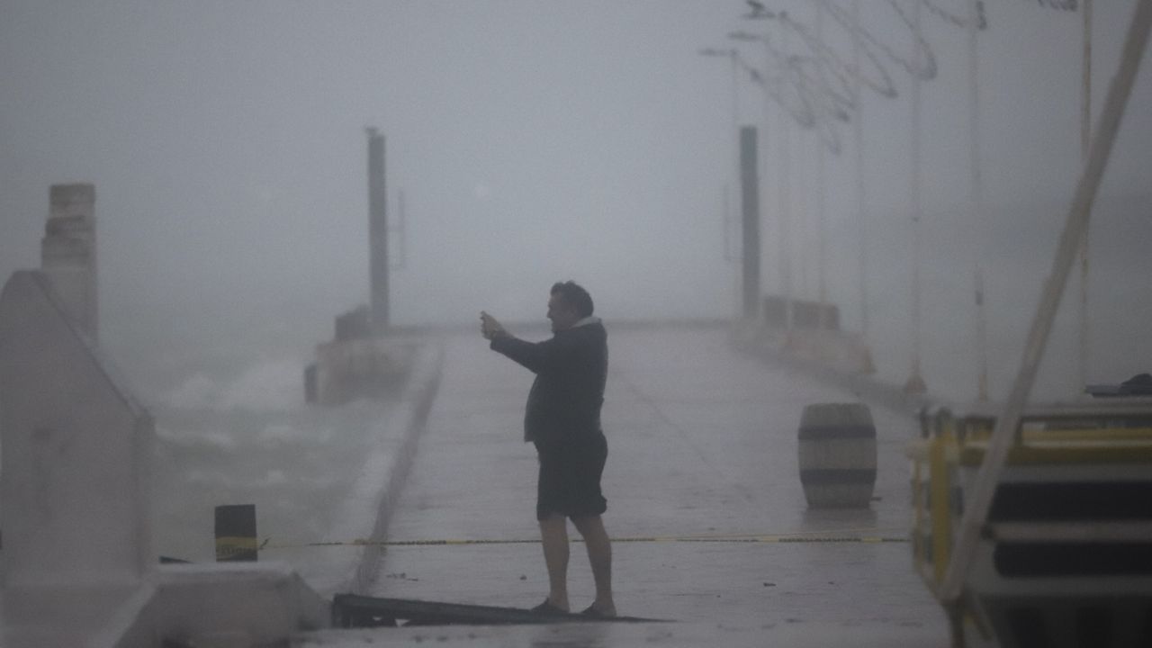 A person takes photos at the harbor amid rain as Hurricane Milton passes near Progreso, Yucatan state, Mexico, Tuesday, Oct. 8, 2024. (AP Photo/Martin Zetina)