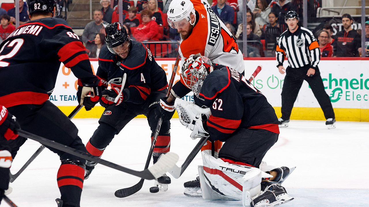 Philadelphia Flyers' Nicolas Deslauriers (44) battles for the puck between Carolina Hurricanes' Shayne Gostisbehere (4) and goaltender Pyotr Kochetkov (52) with Jesperi Kotkaniemi (82) nearby during the first period of an NHL hockey game in Raleigh, N.C., Tuesday, Nov. 5, 2024. (AP Photo/Karl B DeBlaker)