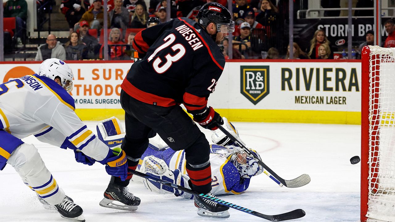 Carolina Hurricanes' Stefan Noesen (23) flips the puck past Buffalo Sabres goaltender Eric Comrie (31) for a goal during the second period of an NHL hockey game in Raleigh, N.C., Saturday, Dec. 2, 2023. (AP Photo/Karl B DeBlaker)