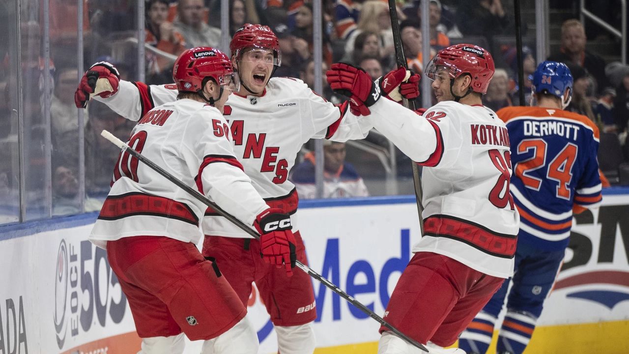 Carolina Hurricanes' Eric Robinson, Martin Necas (88) and Jesperi Kotkaniemi (82) celebrate a goal against the Edmonton Oilers during the third period of an NHL hockey game in Edmonton, Alberta, on Tuesday, Oct. 22, 2024. (Jason Franson/The Canadian Press via AP)