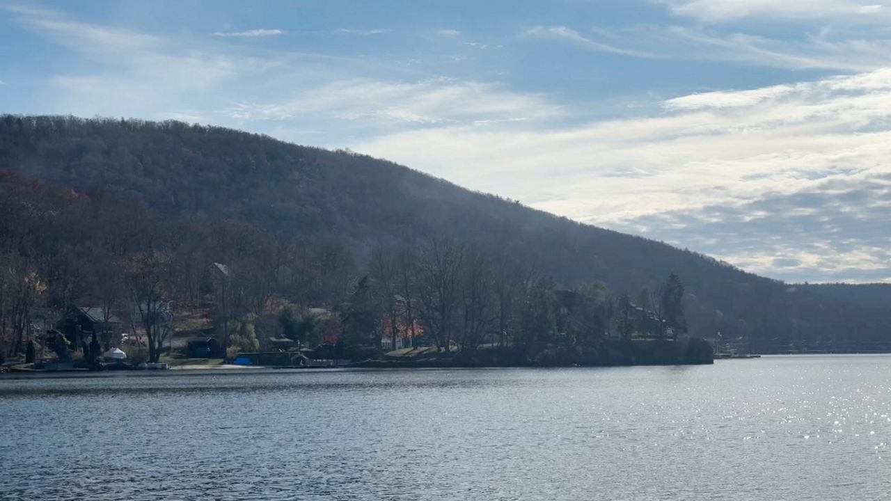 faint smoke from wildfire amid trees in hudson valley along water