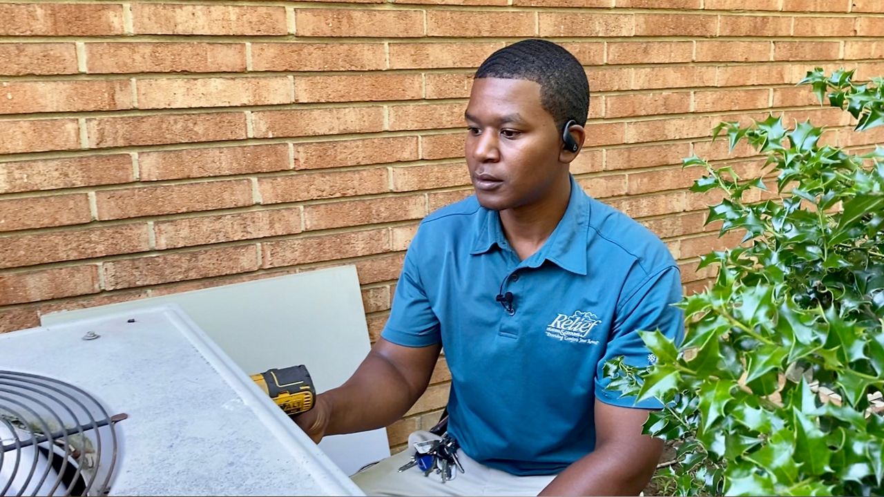 Daniel Harris works on an HVAC unit in Greensboro.