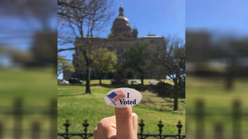Austinite shows off her I Voted sticker in front of the Texas State Capitol. (Spectrum News: Claire Ricke)