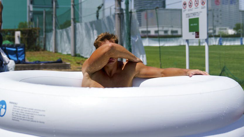 Argentina's Santiago Mare soaks in an ice bath following a men's rugby sevens practice at the Tokyo 2020 Olympics, in Tokyo, Friday, July 23, 2021. (AP Photo/David Goldman)