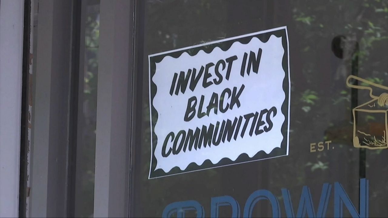 A window sign that reads, "Invest in Black Communities." 