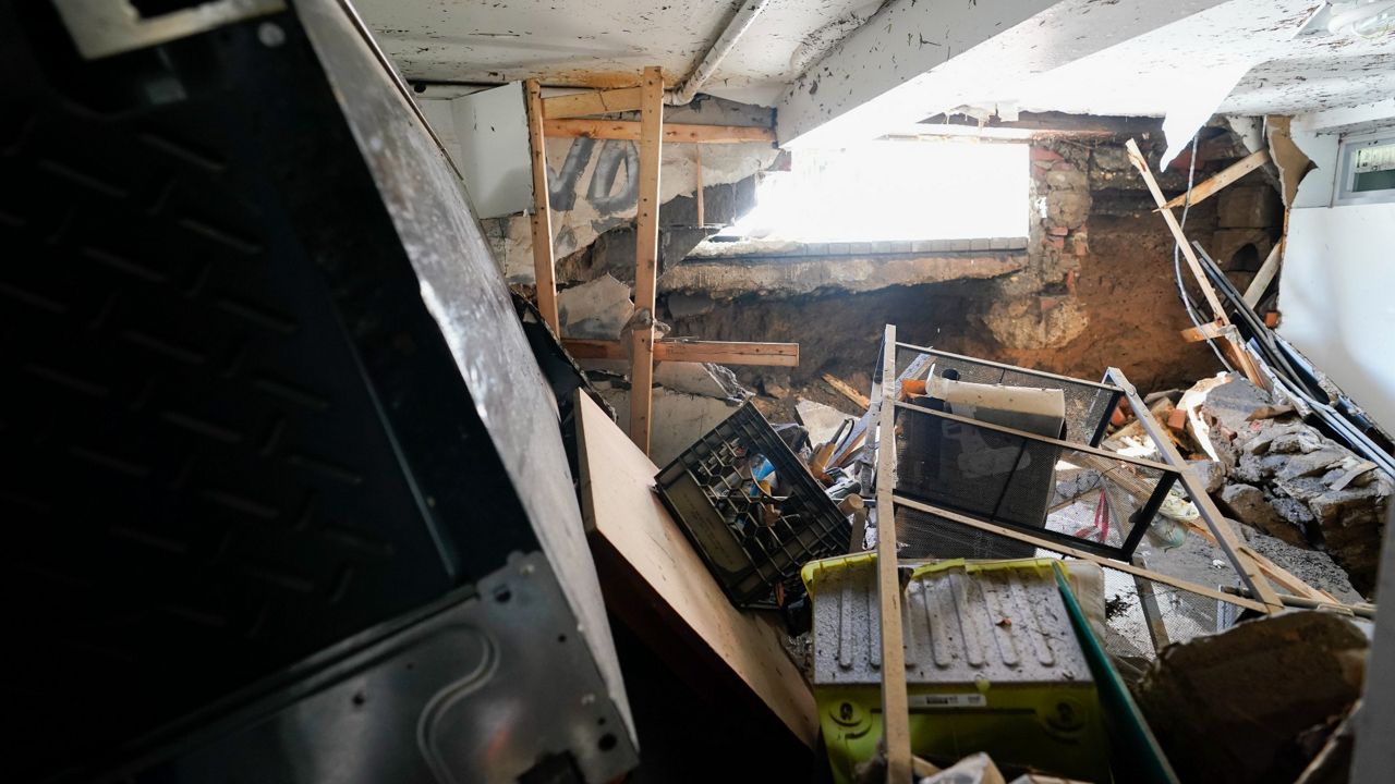 A basement apartment in a Queens building is filled with debris after floodwater pushed through a ground level window, creating a hole in the building's foundation. 
