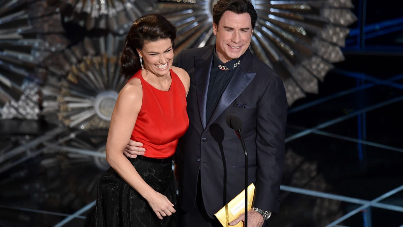 Idina Menzel, left, and John Travolta present the award for best original song at the Oscars on Sunday, Feb. 22, 2015, at the Dolby Theatre in Los Angeles. (Photo by John Shearer/Invision/AP)