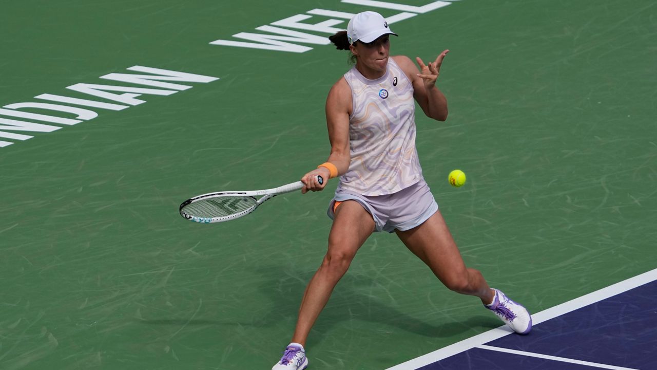 Iga Swiatek, of Poland, returns a shot to Claire Liu at the BNP Paribas Open tennis tournament Saturday, March 11, 2023, in Indian Wells, Calif. (AP Photo/Mark J. Terrill)