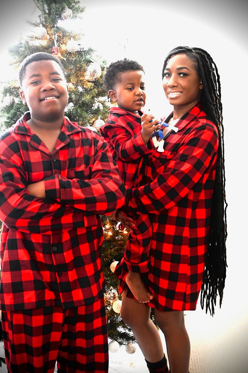 (Left to right): Mario, Major and Ericka Patterson pose for a family photo in front of a Christmas tree. (Provided)