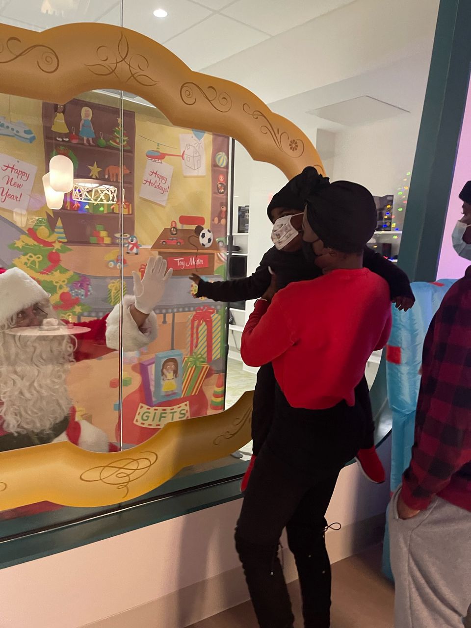 Ericka Patterson holds her son, Major, as he greets Santa Claus at Cincinnati's Ronald McDonald House (Spectrum News/Casey Weldon)