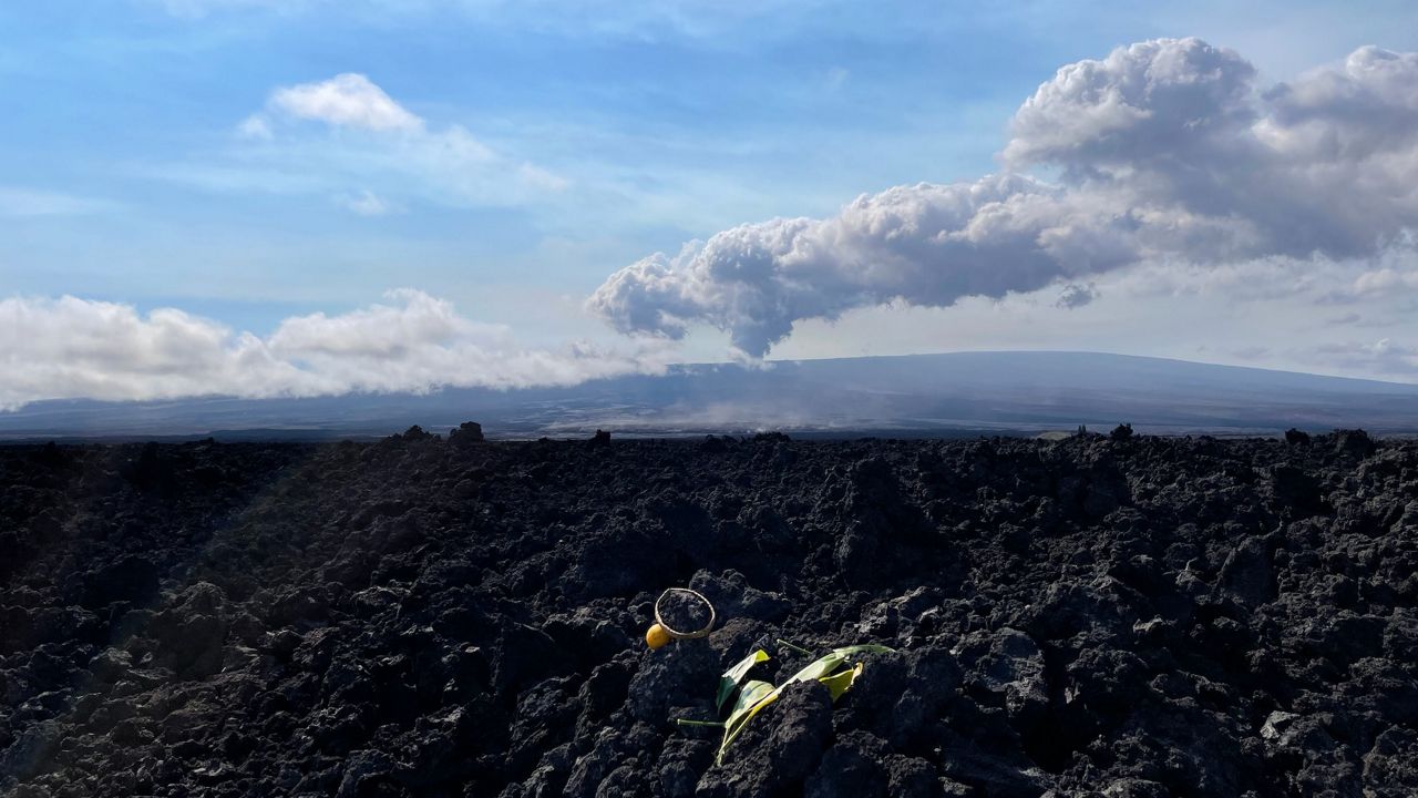 Volcano plumes from Mauna Loa are seen in the background, while hookupu (offerings) are seen in the foreground. (Spectrum News/Michelle Broder Van Dyke)