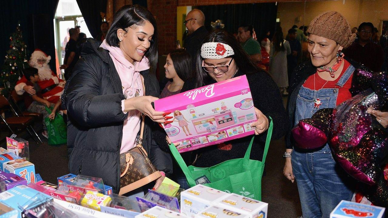 Rapper Saweetie hands out a gifts to kids during a toy distribution event in 2020. (Courtesy Lyle Del Mundo)