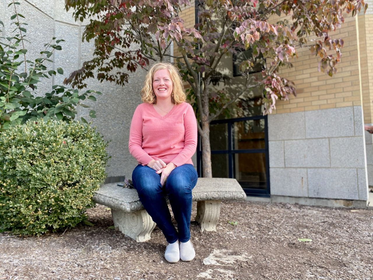 Julie Krommer sits outside St. Ignatius of Loyola Church. She's attended Mass there her entire life. (Spectrum News/Casey Weldon)