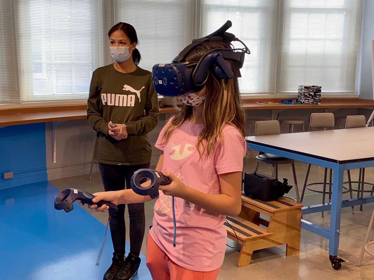 Eighth-grader Jayda Brehm stands alongside her classmate, Audrina Kiaaina, as she uses a new VR set at Sayler Park School (Spectrum News/Casey Weldon)