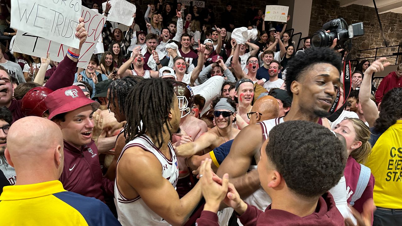 The Fordham men's basketball team celebrates a win with their fans on Wednesday. (NY1/Roger Clark)