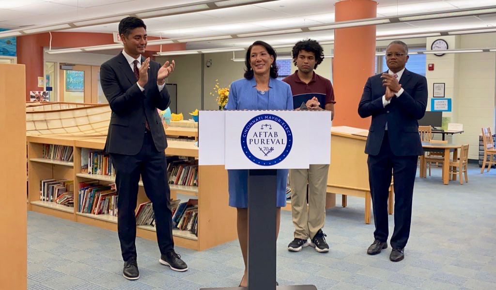 Mayor-elect Aftab Pureval (left) applauds Jan-Michele Lemon Kearney after announcing her as Cincinnati's next vice mayor. Her son, Asher (center) and husband, Eric Kearney (right) also surround here. (Spectrum News/Casey Weldon)