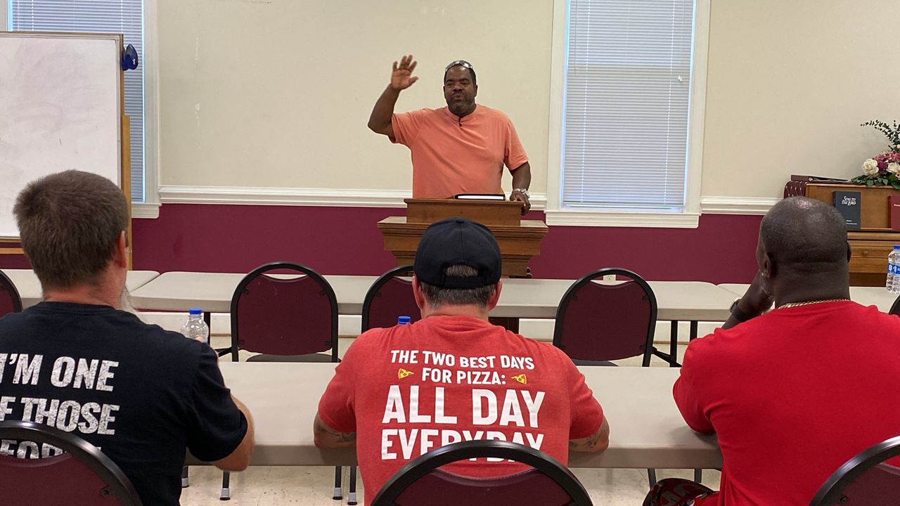 Artemus Carter shares his testimony at a meeting for Transition To Work program graduates. (Spectrum News 1/Noelle Lashley)