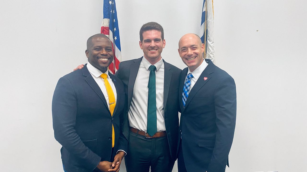 Council member Reggie Harris (L), Seth Walsh (C) and Congressman-elect Greg Landsman pose for a photo at City Hall. (Casey Weldon/Spectrum News 1)