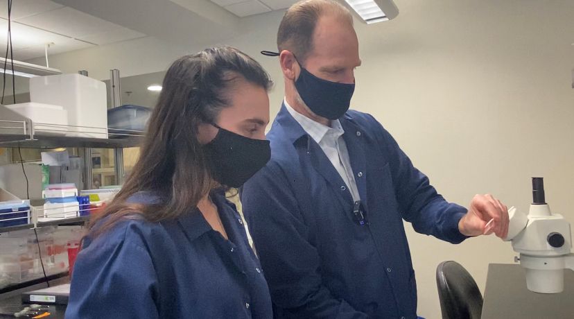 Professor works in lab with student