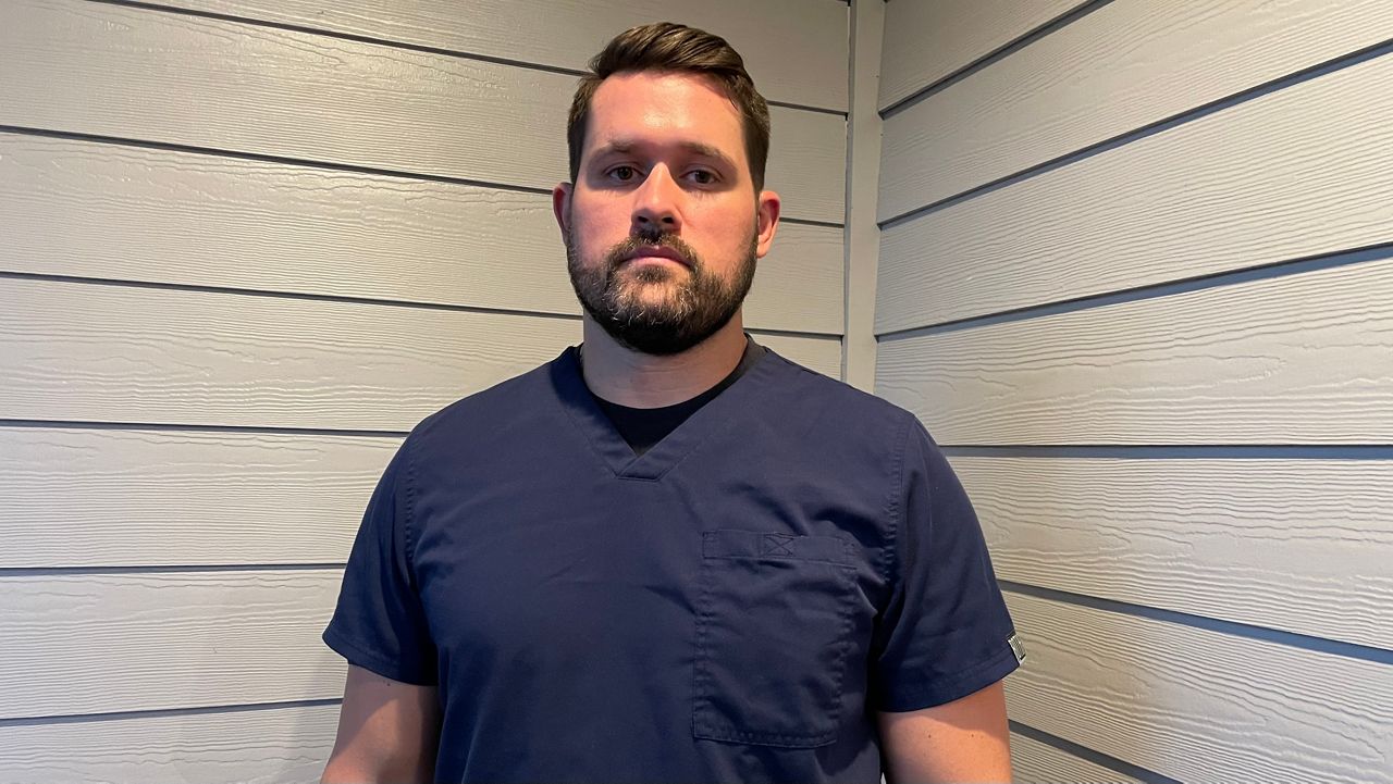 U.S. Army Veteran Devin Yates wearing scrubs before going to graduate school 