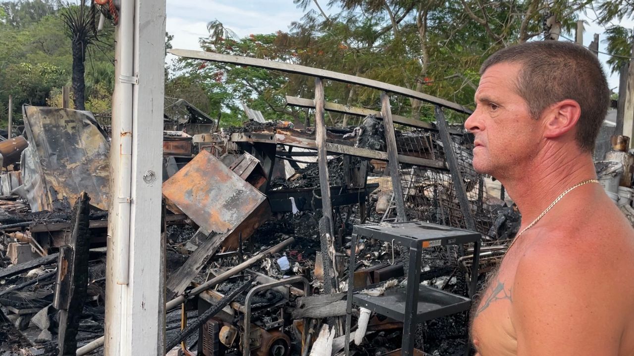 Russell Dingman looks over damaged by Friday's brushfire — he says he's lived in the area for nearly 10 years and can’t recall damage this extensive from a fire. (Spectrum News 13/Brandon Jones)