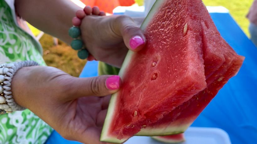 Emory New holds fresh slices of watermelon. (Spectrum News 1/Rachel Boyd)