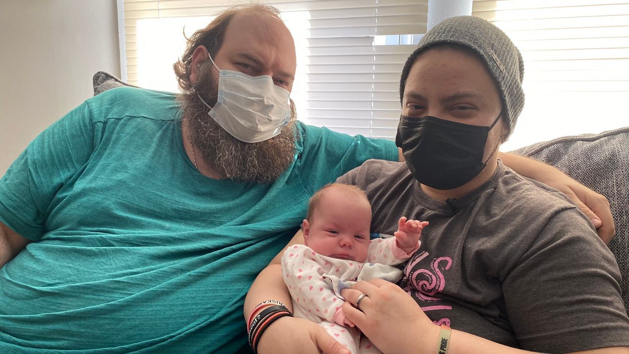 Duane Danielson and Liam Johns pose for a photo with their child Sequoia.