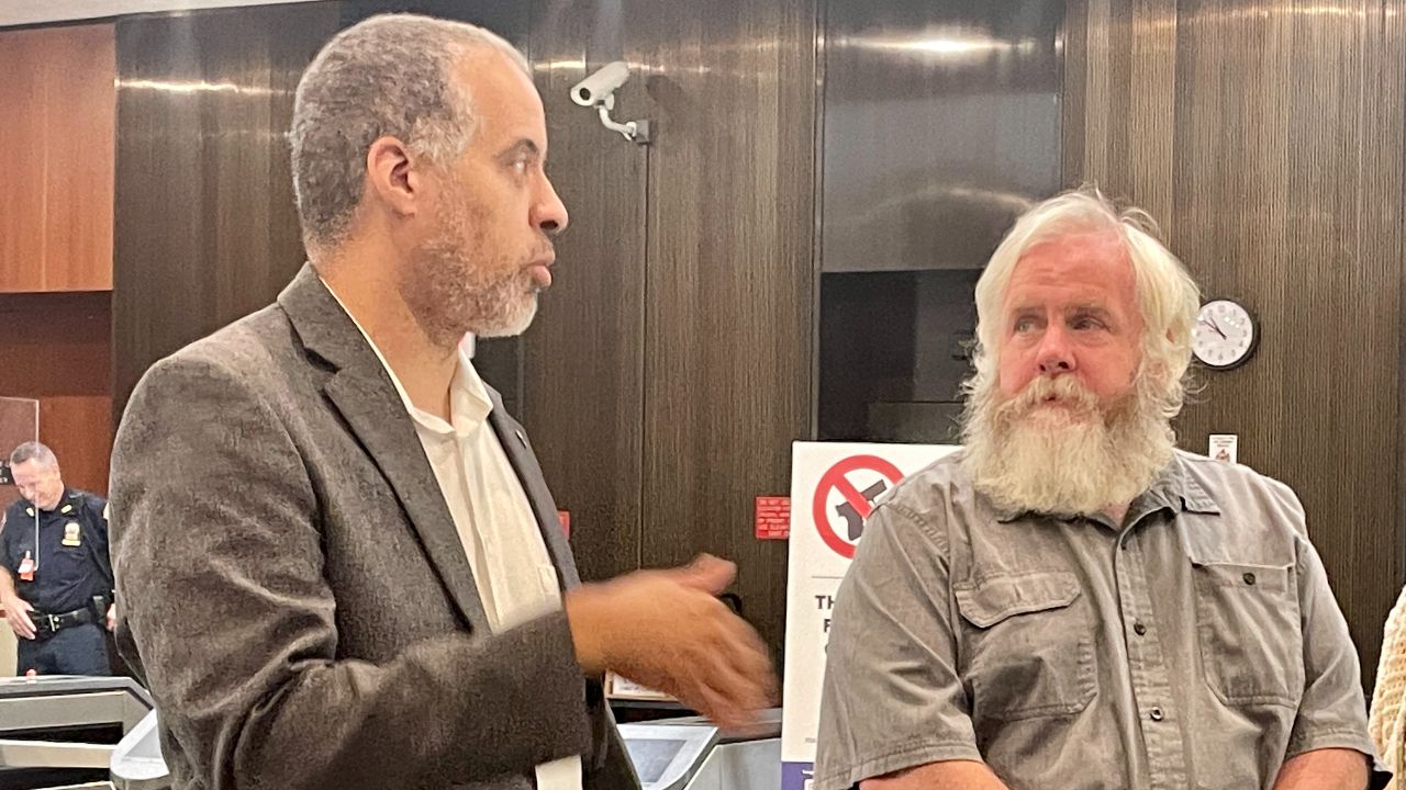 Left, Larry Sharpe speaks with a group of supporters in Albany after Friday's hearing as Putnam County Libertarian Party Committee Chair William O'Donnell listens.