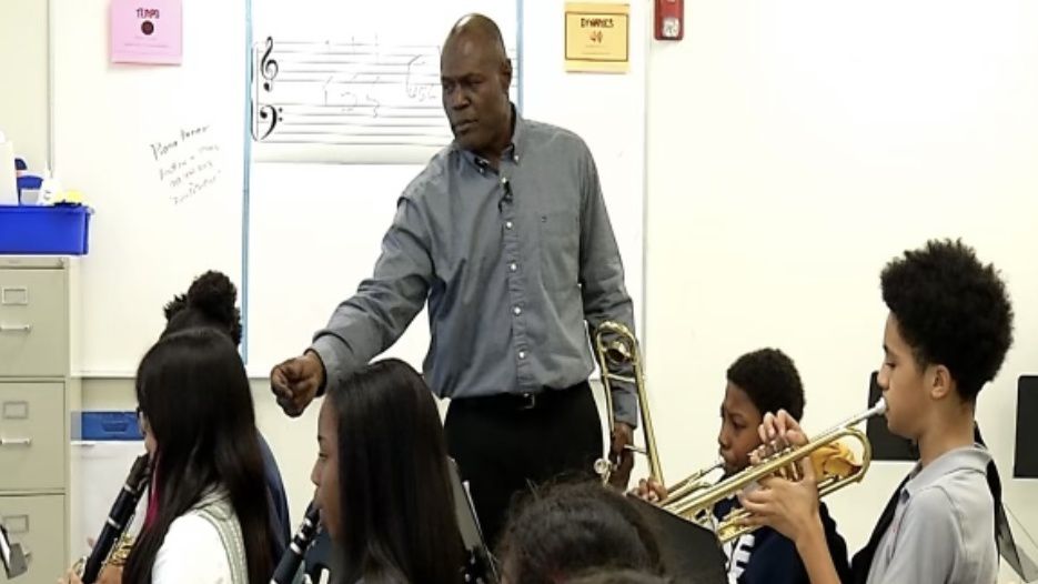 Rise Southeast Raleigh Charter School band teacher Daryl White shows students how to play instruments