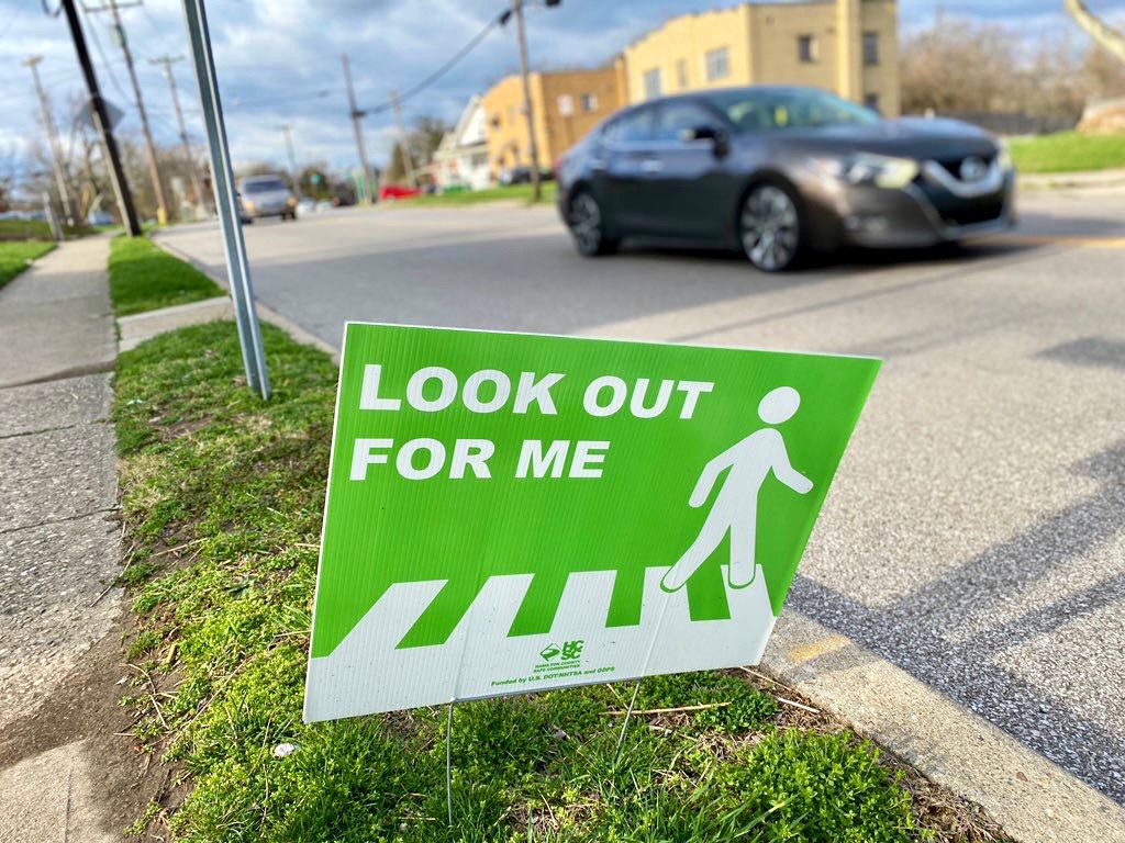 A sign reminding drivers to look out for pedestrians posted along busy McHenry Avenue in East Westwood. (Casey Weldon/Spectrum News 1)