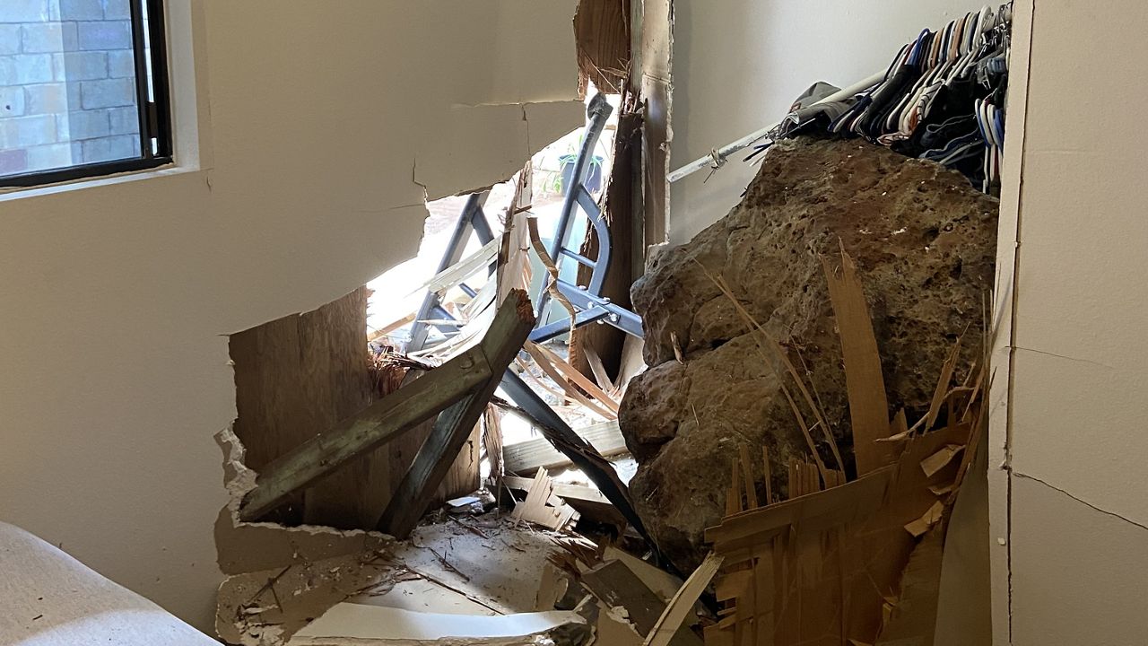 A boulder crashes through a wall and into an Aiea home