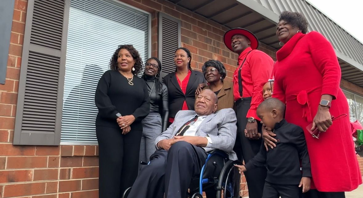 Carlos Parks poses for a picture with his family outside his new agency.