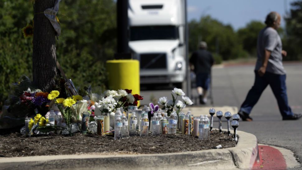 A man leaves a make-shift memorial in the parking lot of a Walmart store near the site where authorities Sunday discovered a tractor-trailer packed with immigrants outside a Walmart, Wednesday, July 26, 2017, in San Antonio. Several people died and others hospitalized after being crammed into a sweltering tractor-trailer in the midsummer Texas heat in what authorities describe as an immigrant-smuggling attempt gone wrong. (AP Photo/Eric Gay)