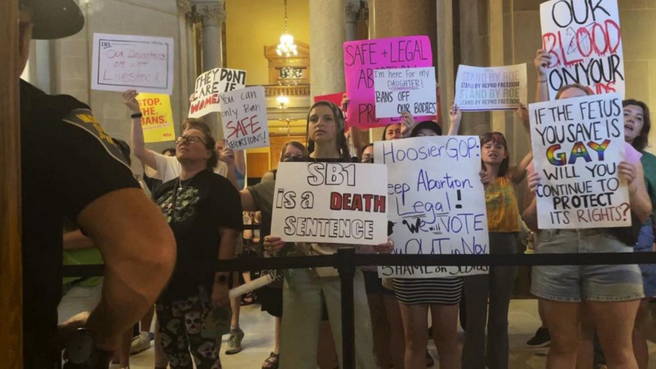 Abortion-rights protesters fill Indiana Statehouse corridors and cheer outside legislative chambers, Friday, Aug. 5, 2022, as lawmakers vote to concur on a near-total abortion ban, in Indianapolis. (AP Photo/Arleigh Rodgers)