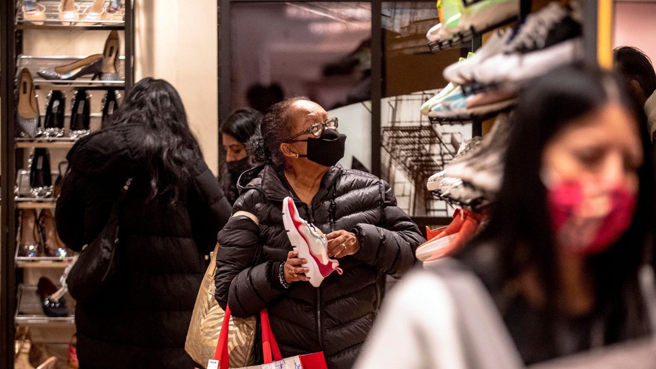 People wear masks inside a shoe store in this file image. (AP Photo)