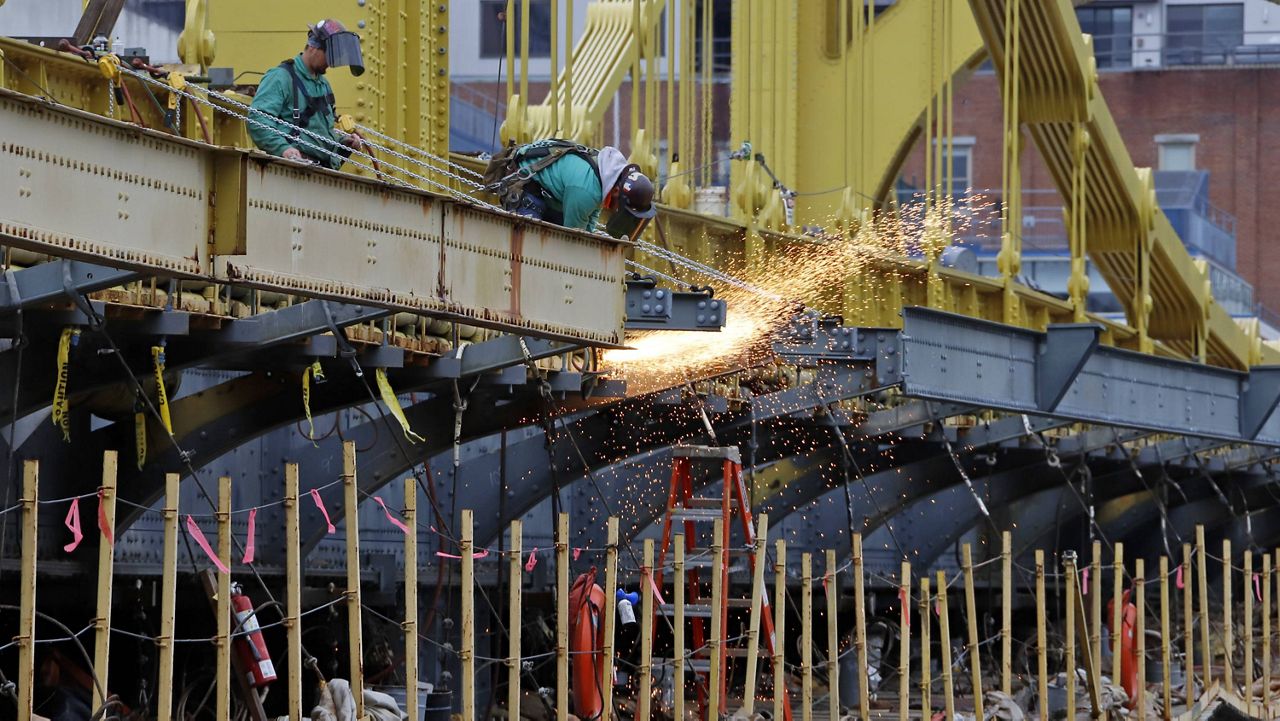 In this May 6, 2020, file photo a worker welds on the Ninth Street bridge in Pittsburgh. (AP Photo/Gene J. Puskar, File)
