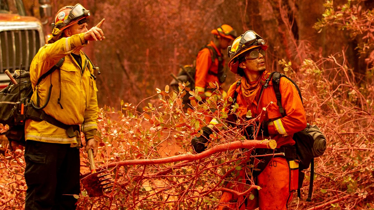 Inmate firefighters clear brush while battling the Fawn Fire burning north of Redding in Shasta County, Calif., on Thursday, Sep. 23, 2021. (AP Photo/Ethan Swope)