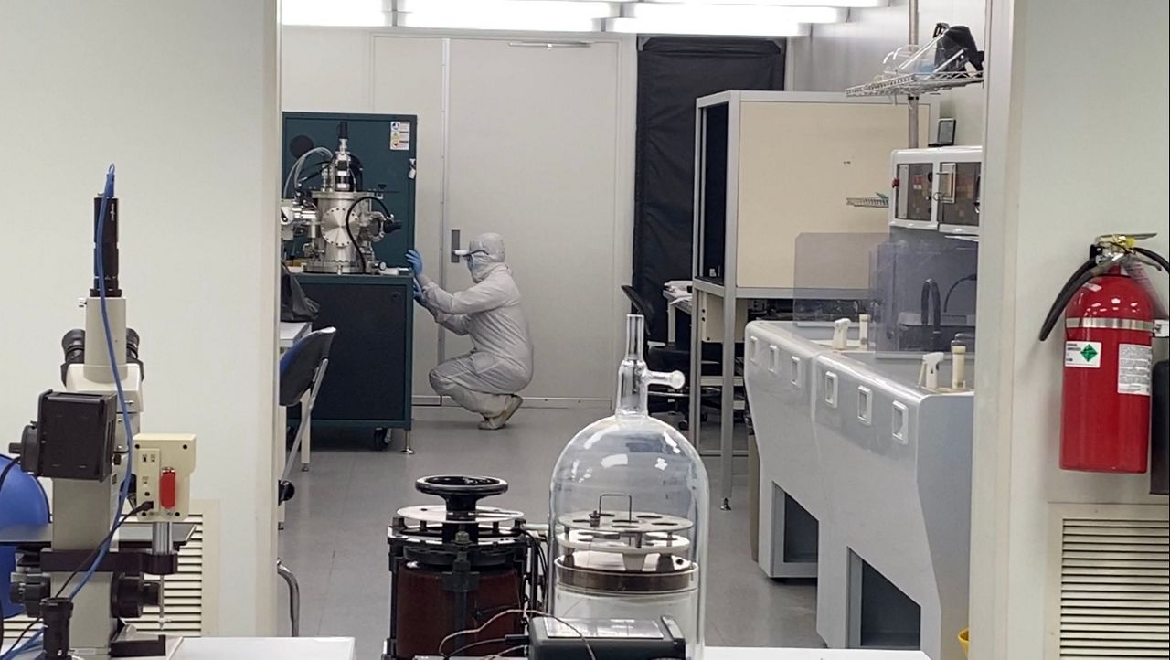 A UC student works in the university's cleanroom lab