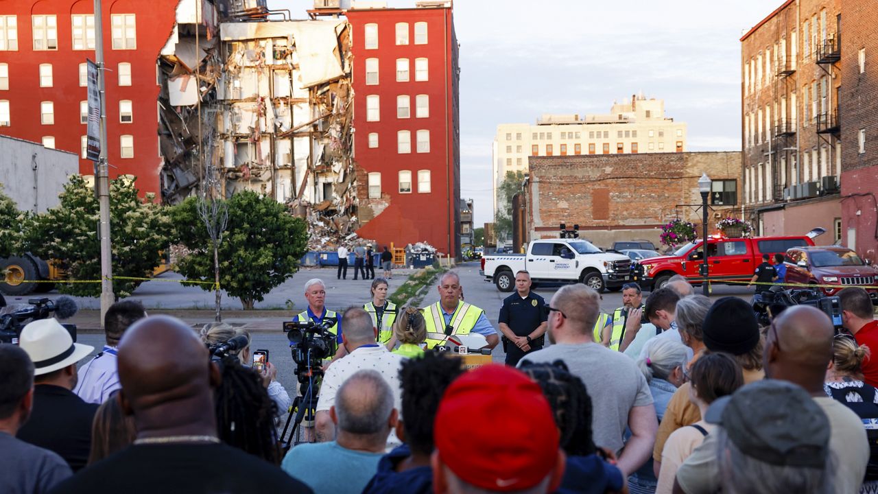 Officials update the media, residents and onlookers Sunday after a partial building collapse in Davenport, Iowa. (Nikos Frazier/Quad City Times via AP)