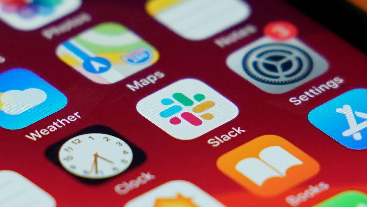The Slack app icon is displayed on an iPhone screen, Tuesday, Dec. 1, 2020, in Long Beach, Calif. In a deal announced Tuesday, business software pioneer Salesforce.com is buying work-chatting service Slack for $27.7 billion in a deal aimed at giving the two companies a better shot at competing against longtime industry powerhouse Microsoft. (AP Photo/Ashley Landis)
