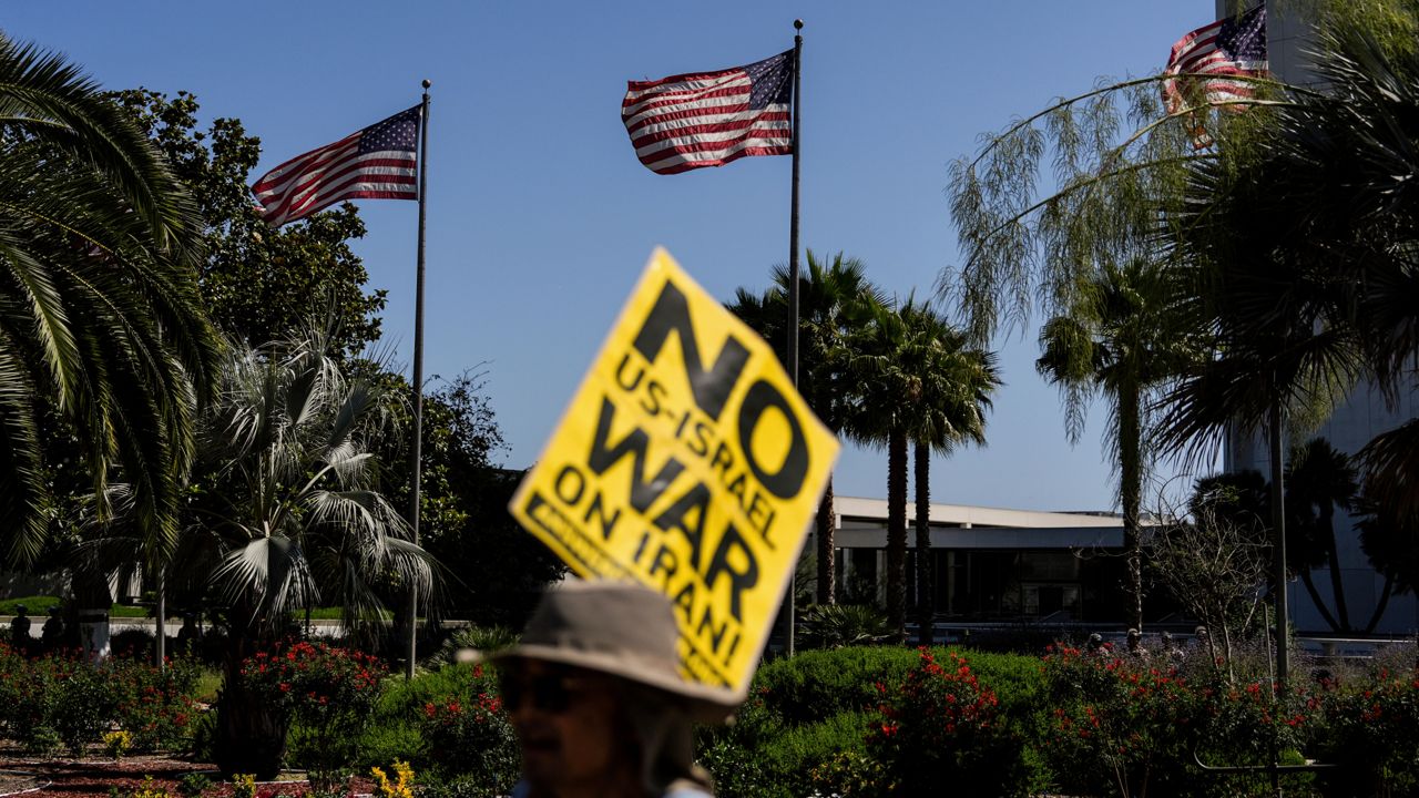 An anti-war demonstrator holds a sign outside the Wilshire Federal Building in Los Angeles on Sunday, following U.S. airstrikes on Iran's nuclear facilities. (AP Photo/Jae C. Hong)